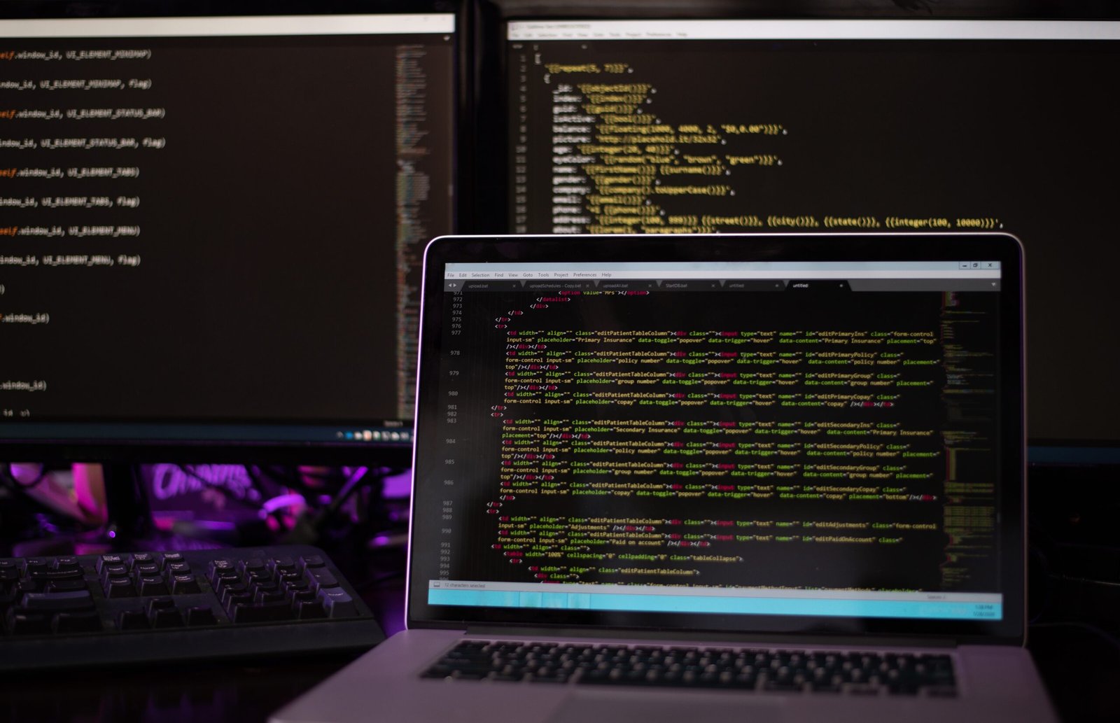 three computer screenswith computer programming